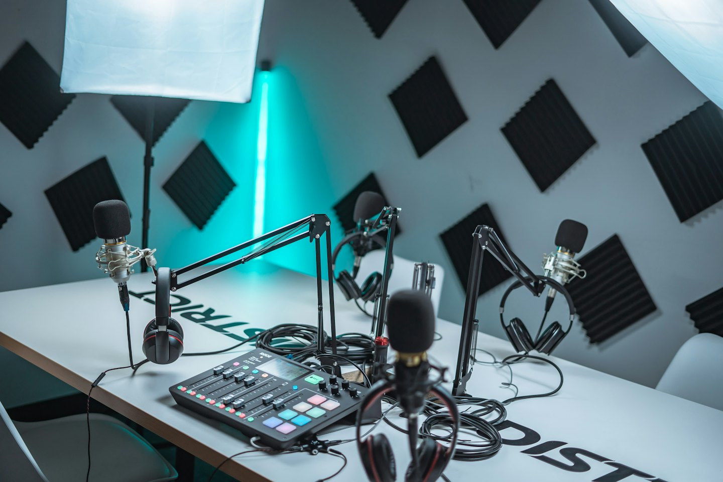 Podcast studio with microphones, headphones, and audio mixer.
